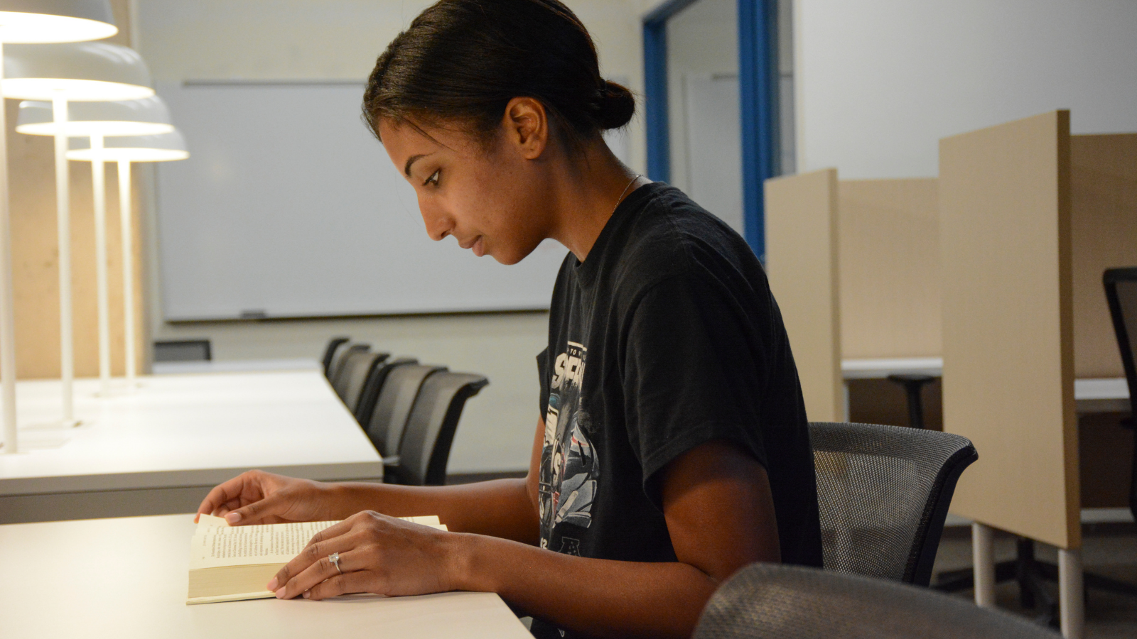 A student reading a book in the Penn Museum Library.