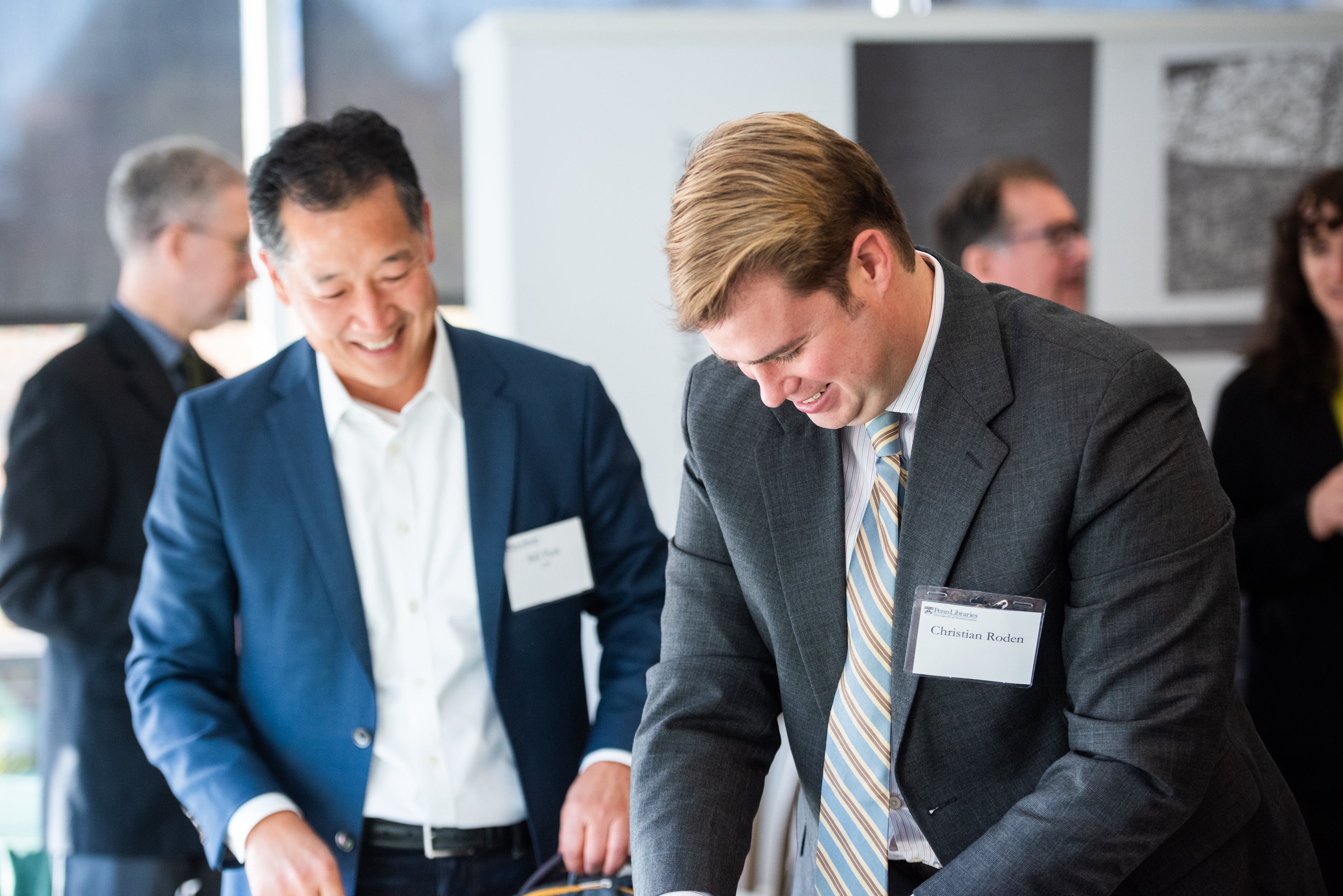 Smiling men in suits wearing nametags