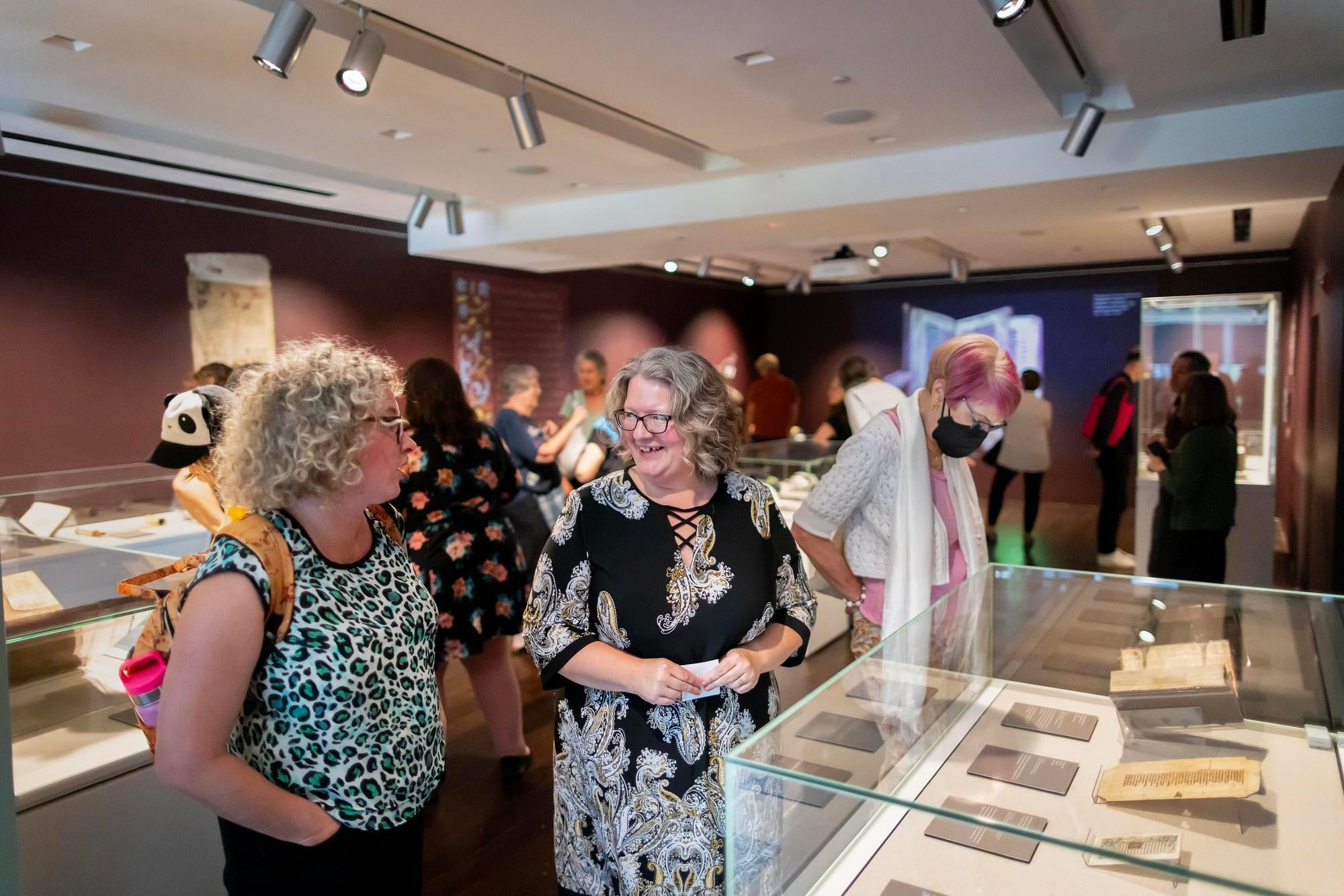 Curator and guest speak in front of a display of books in the Goldstein gallery
