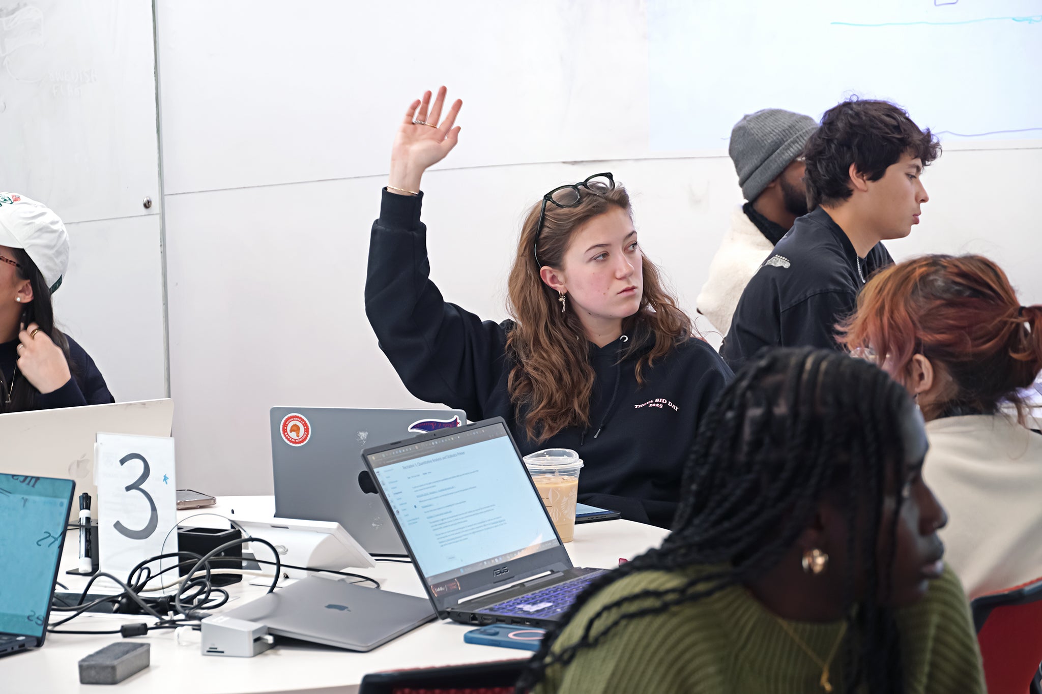 Student raising hand in classroom setting