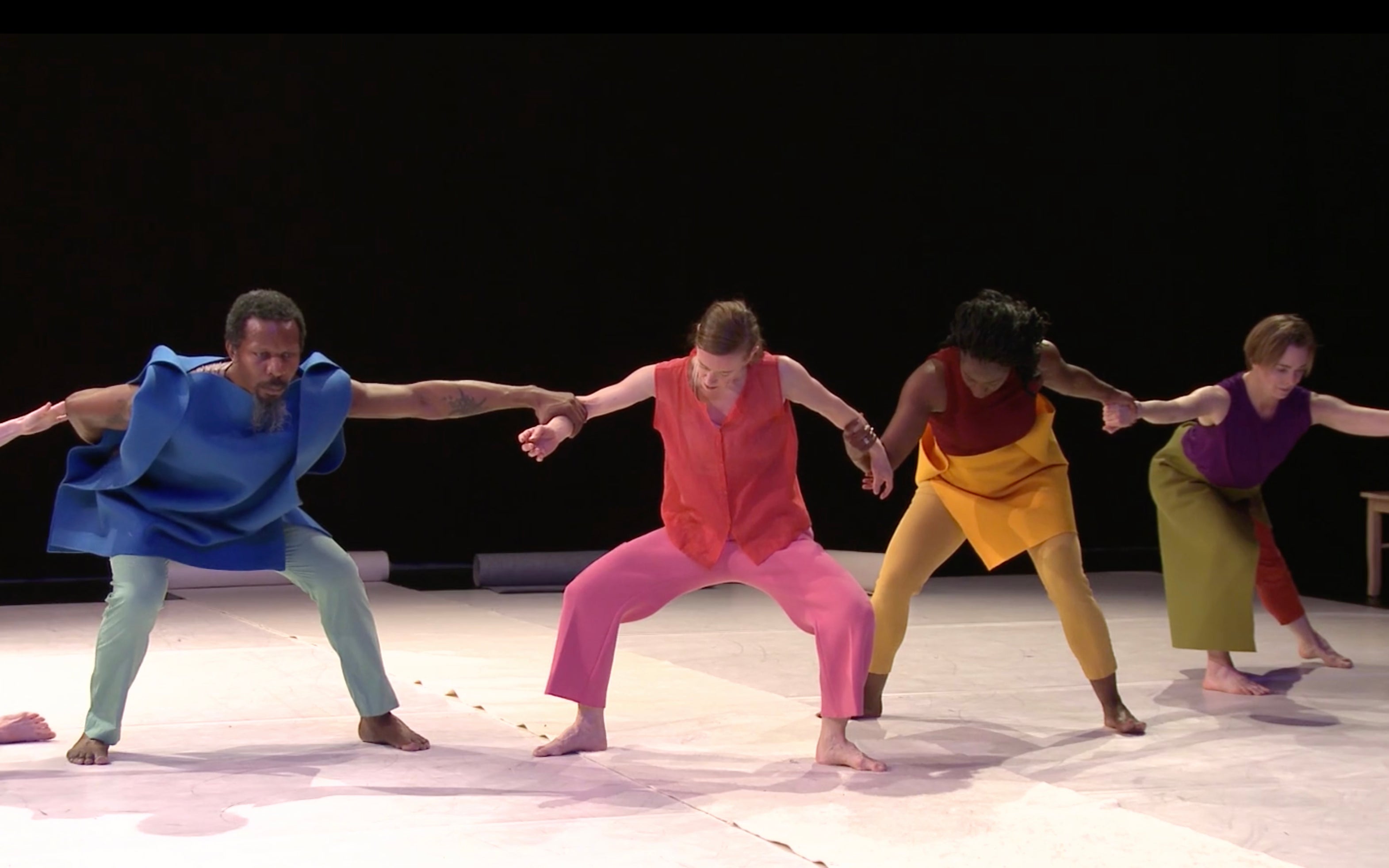 Four dancers holding hands.