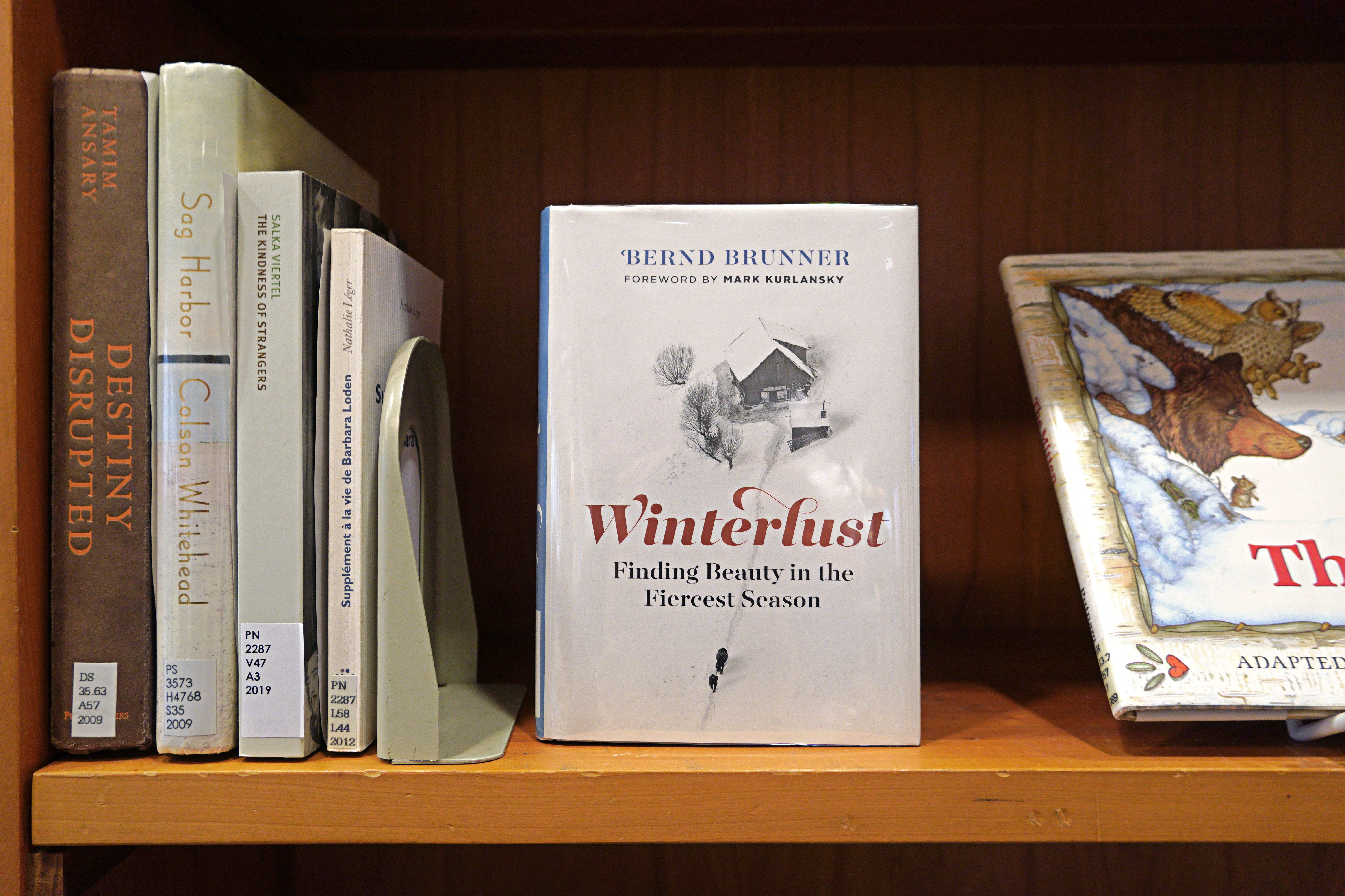 The book Winterlust is displayed on a shelf next to other titles.