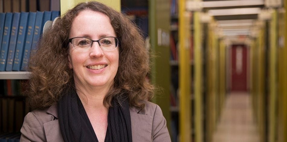 Liza Vick standing among the library stacks.