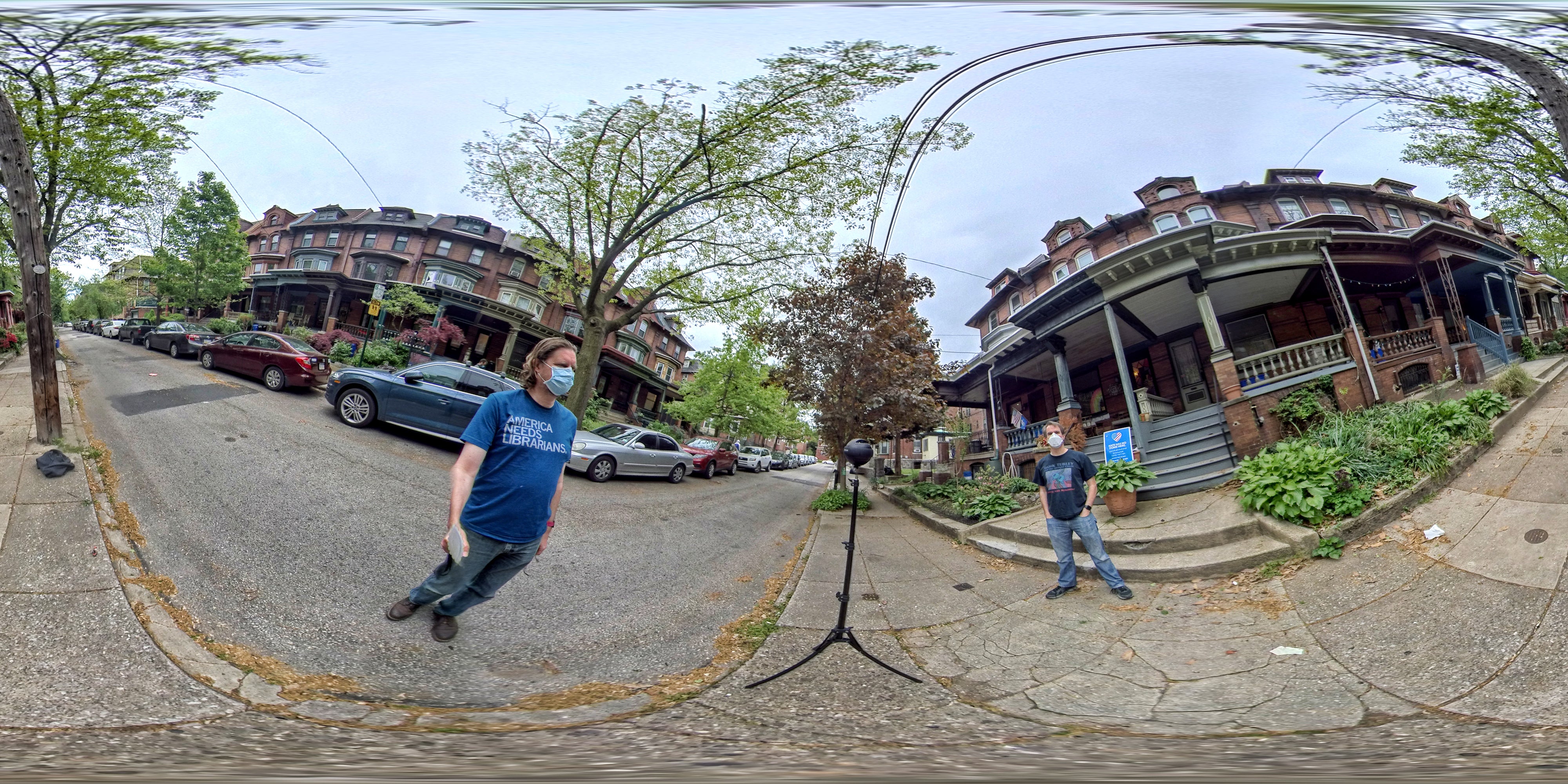 Two people standing across from each other on a street. The image is heavily warped.