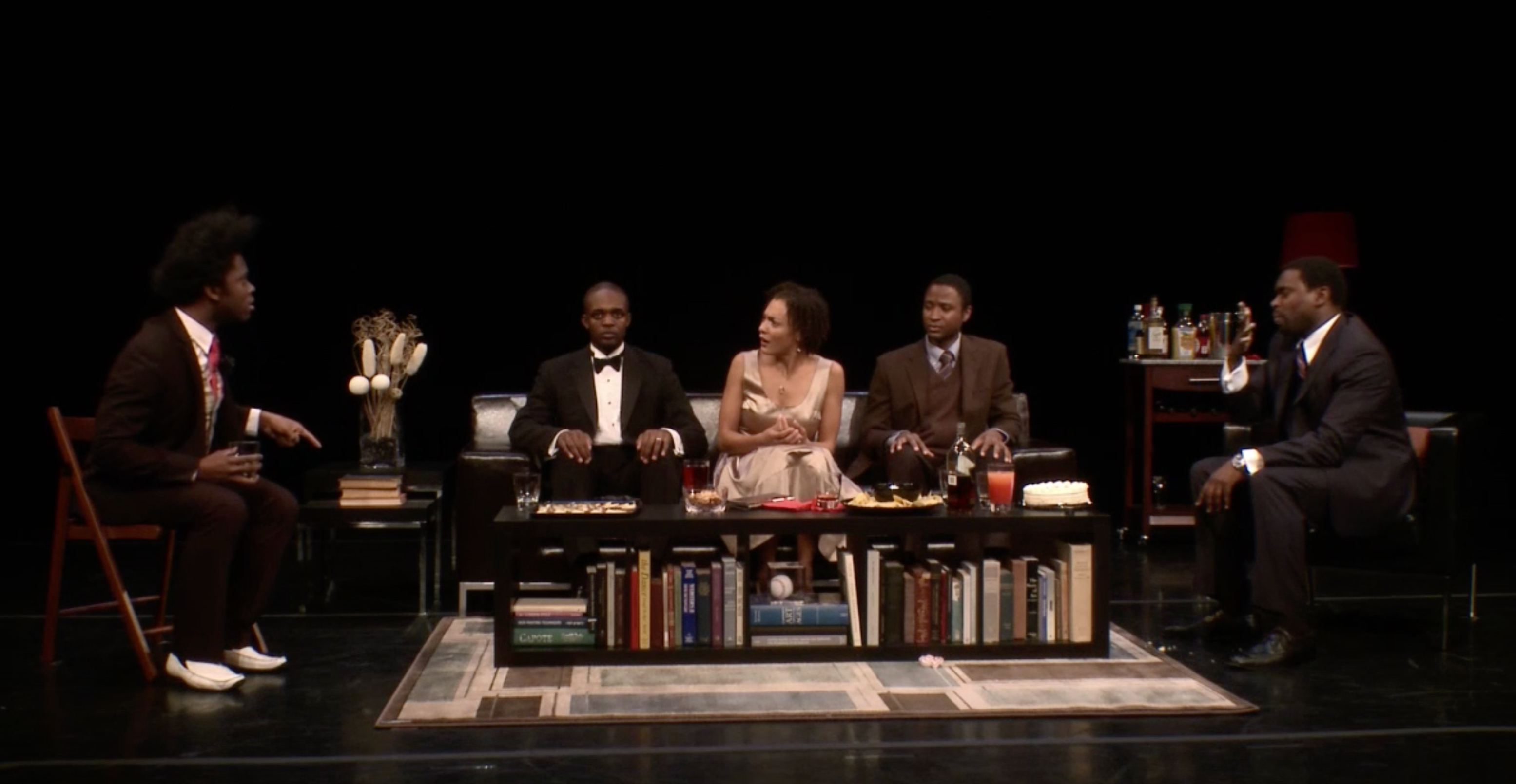 Actors on stage, three on couch and two in chairs.
