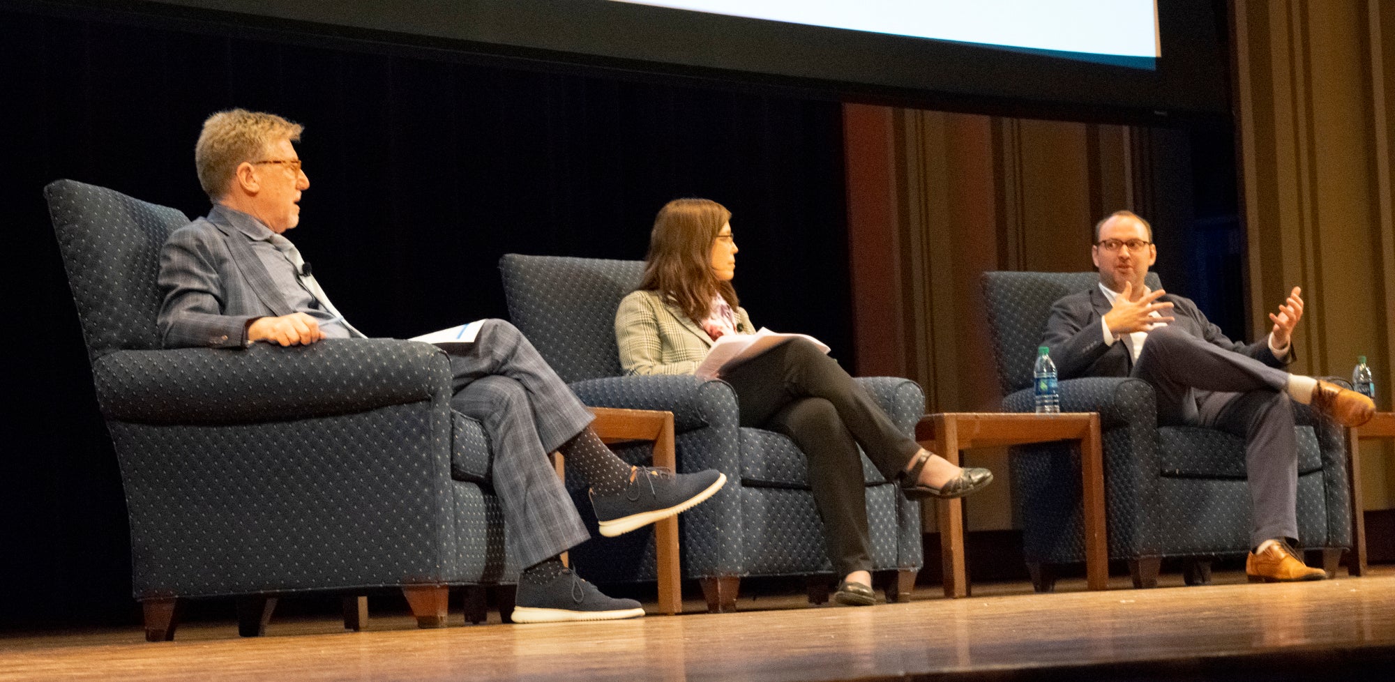 David Fox, Emily Hannum, and Jon Shaw sitting on stage talking to an audience.