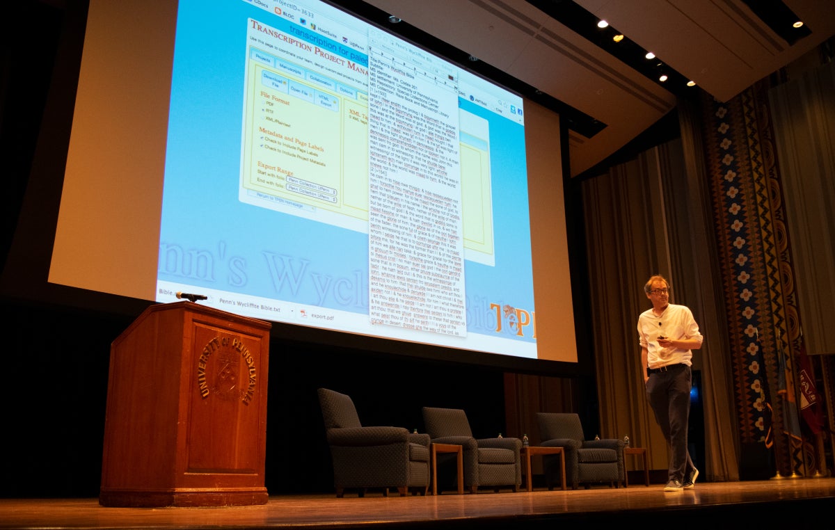 Will Noel standing in front of a screen giving a presentation.