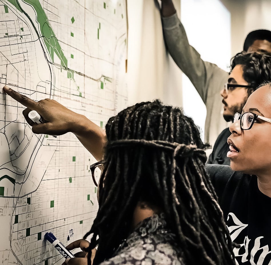 Students pointing at map on wall